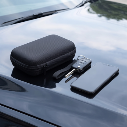 Carry case on a car bonnet beside car keys and a smartphone for size comparison